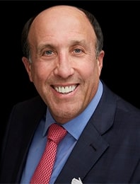 Smiling man in suit with red tie.